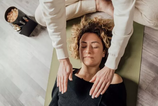 soin énergétique femme allongée thérapeute soin par les mains